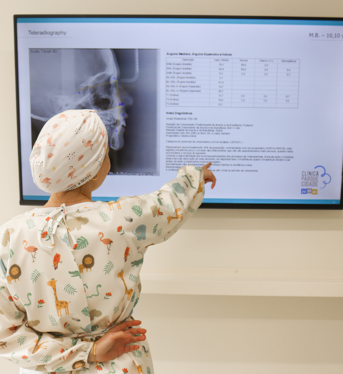 Profissional de ortodontia infantil a analisar radiografia no ecrã