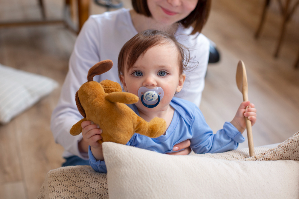 Bebé com chupeta e peluche no colo da mãe antes do processo de remoção de chupeta